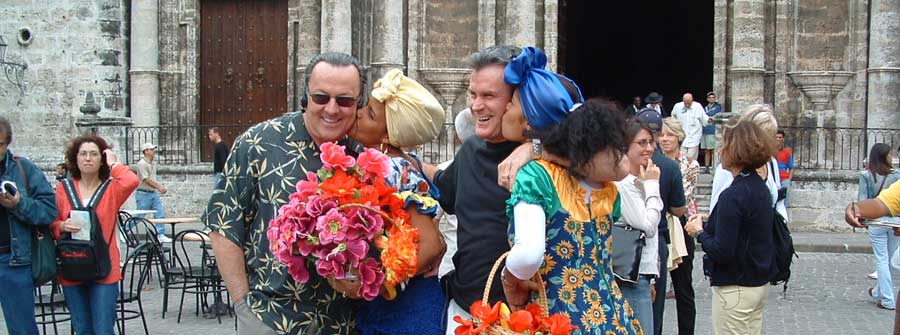 3 of 10, Two men getting kissed on the cheek by women holding bouquets of flowers