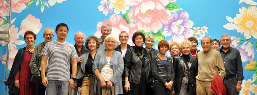 7 of 10, Large group of people posing in front of a mural of flowers