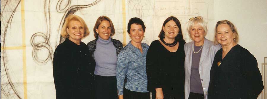 5 of 10, A group of women posing in front of a large sketch of a sculpture