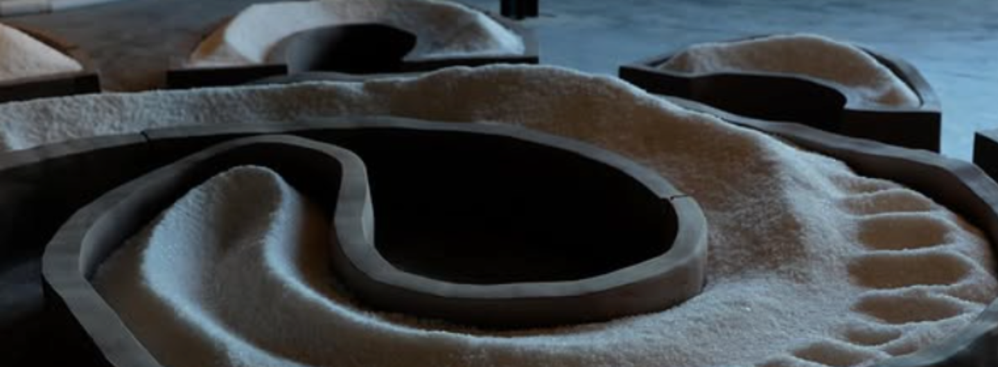 a dark swirling sculpture filled with sand